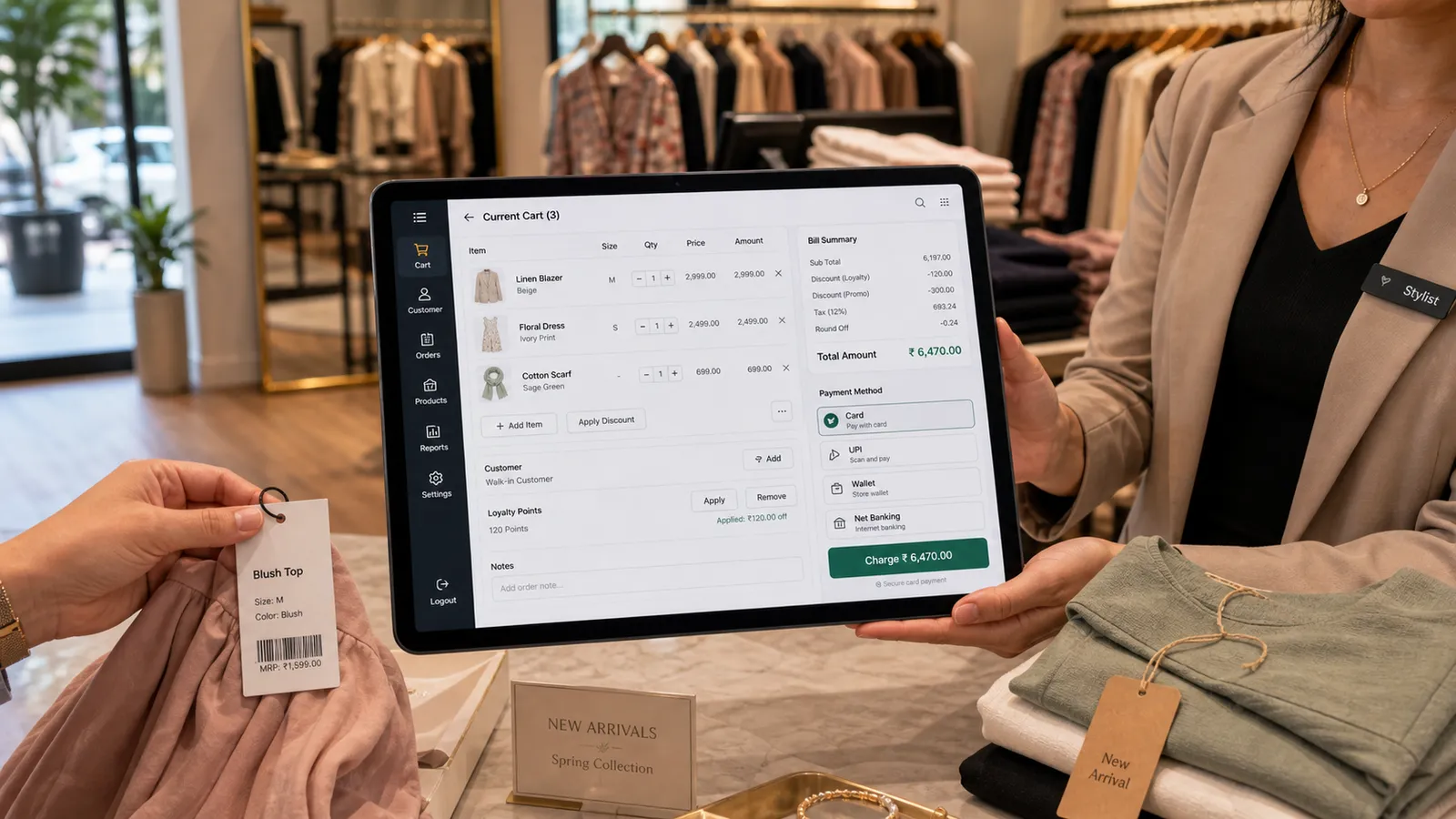 Stylist billing on a Folio tablet POS beside tagged garments in a boutique